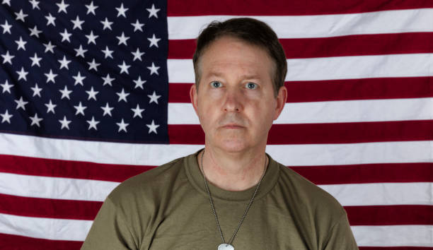 istock Man wearing military undershirt and ID tags with US flag in background 1306394740