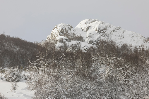 high mountain rocks over snowy forest in León, CL, Spain