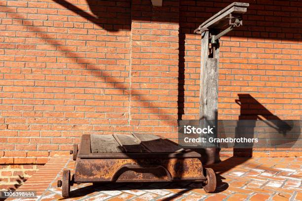 A Vintage Rusty Industrial Size Platform Scale With Metal Wheels And A Beam Balance Stock Photo - Download Image Now