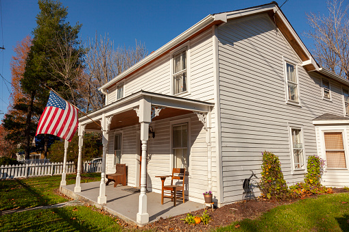 Clifton, VA, USA 11-14-2020: A two story, white, wooden, well preserved, vintage, 19th century single family home located in historic Clifton, a small picturesque town in Fairfax county Virginia.