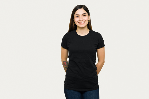 Portrait of a cute young woman smiling and wearing a mock up black t-shirt. Beautiful woman in a t-shirt for design print