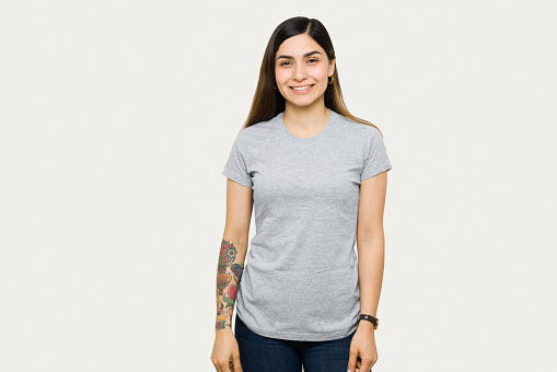 Portrait of a happy woman smiling and wearing a mock up gray t-shirt. Beautiful woman in a t-shirt for design print