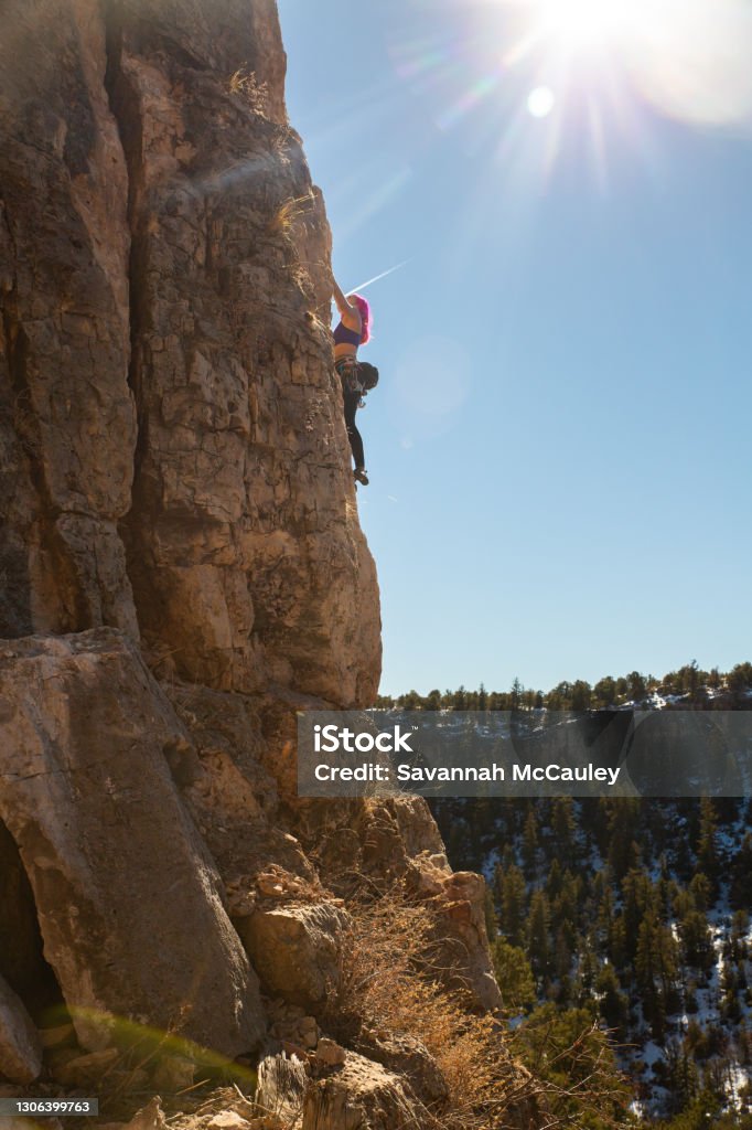Female Climber works up side of climbing arete A woman climbs a route in Colorado Colorado Stock Photo