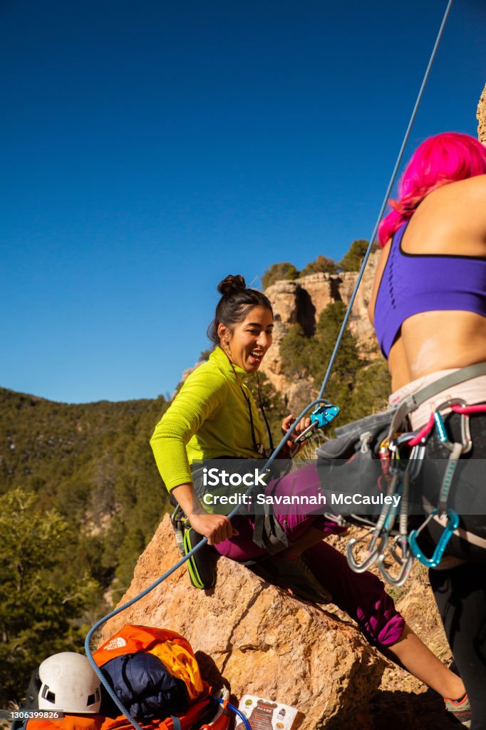Two women climbers start a route A female climbing pair safely  work on a route Rock Climbing Stock Photo