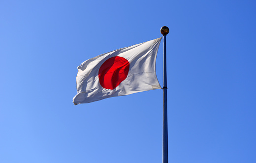 Japanese flag fluttering in the wind against clear sky with copy space.