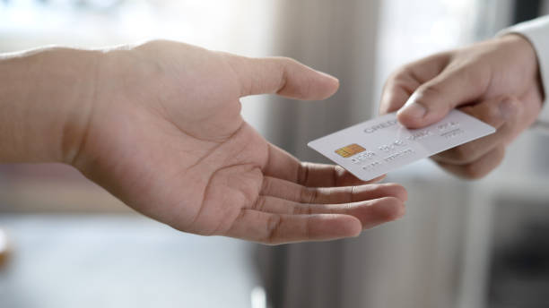 istock Close-up of two hands with credit card 1306414494
