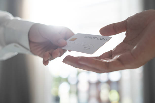 istock Close-up of two hands with credit card 1306414511