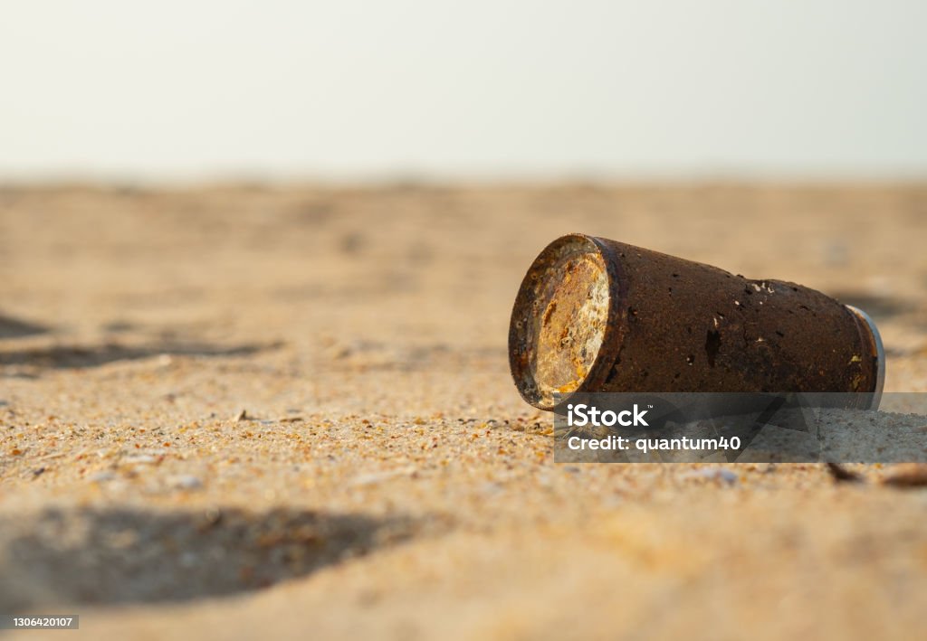 Old rusty can dropped on the sand beach. Old rusty can dropped on the sand beach, environmental problems and global warming. Abandoned Stock Photo