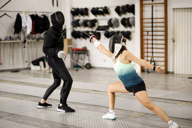 istock Coach and female fencing athlete training with sword 1306420363