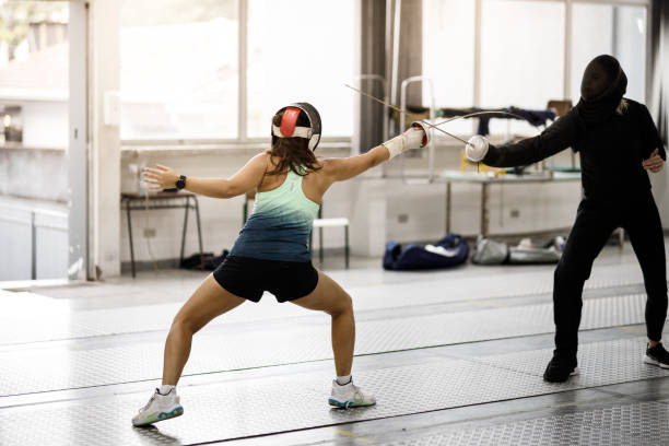 istock female fencing athlete training attack moves with coach 1306420376