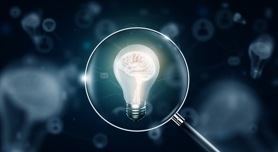 Light bulb with glowing human brain inside. Magnifying glass searching for idea, solution, and inspiration. Business and Technology idea concept. 3D Rendering.