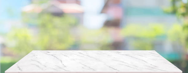 istock spring background.Empty white marble table with blur tree in garden boekh background,banner mockup template for display of product 1306428778