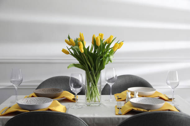 istock Beautiful Easter table setting with yellow tulips indoors 1306434180