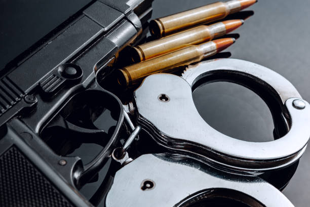 istock Handcuffs and rifle cartridges on black background 1306439320