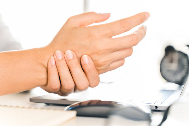 istock Closeup woman holding her hand pain from using computer long time. Office syndrome concept. 1306440073