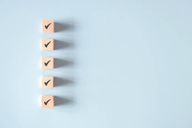 istock Wood cube with check mark on blue background, Checklist concept. 1306440219