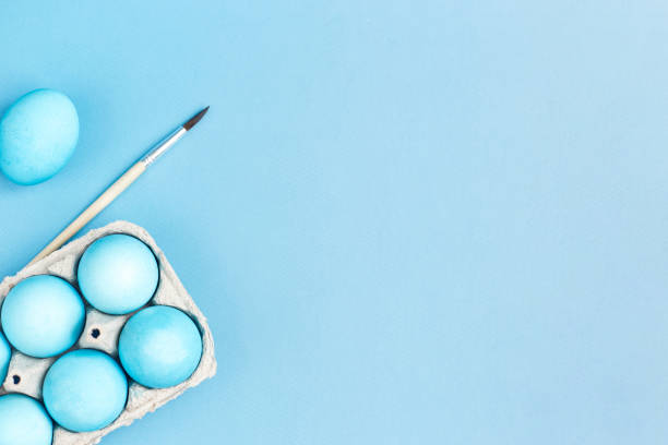istock Happy Easter concept. Chicken eggs painted in blue color in the egg compartment. Preparation for holiday. Blue background copy space 1306441428