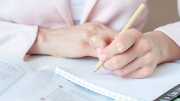 istock a woman writes down information with a pen in a diary 1306442936