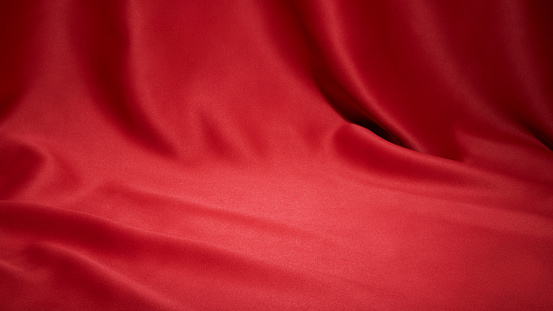 Red cloth waves texture background stage shot in table top for christmas background