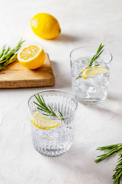 Refreshing lemon drink still life with sparkling water with rosemary and lemon tonic water stock pictures, royalty-free photos & images