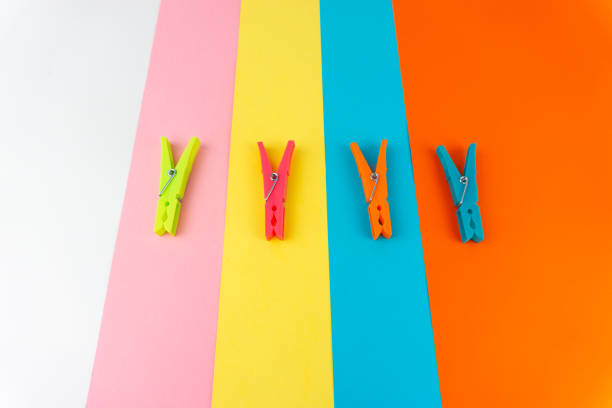 istock Top view of four different colored plastic clothespins on a background with four different colors 1306445475