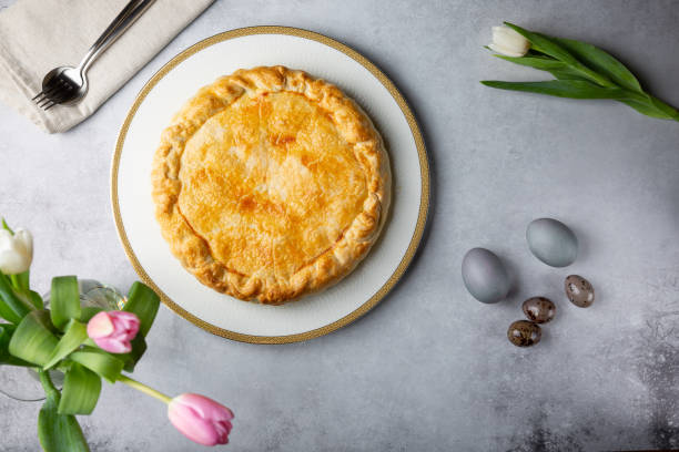 Torta Pasqualina. Traditional Italian savory Easter pie with spinach, chard, ricotta and whole eggs on gray background. Top view.