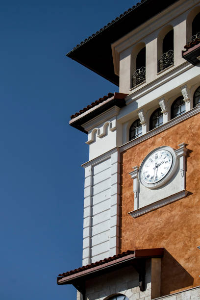 istock The tower is white with a clock in a tory style. Sunny summer day. Front view. 1306448475