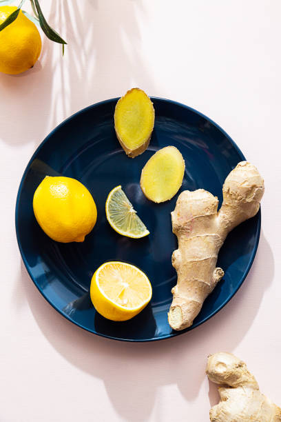 istock Fresh ginger root and lemon whole and halves on a plate on a pink background. Minimalistic composition with ingredients for tea. Healthy food concept, boosting immunity 1306451113