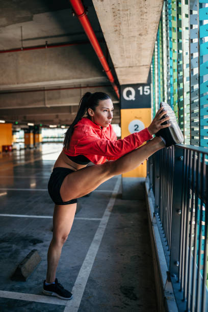 istock Female runner warming up on parking lot 1306451911
