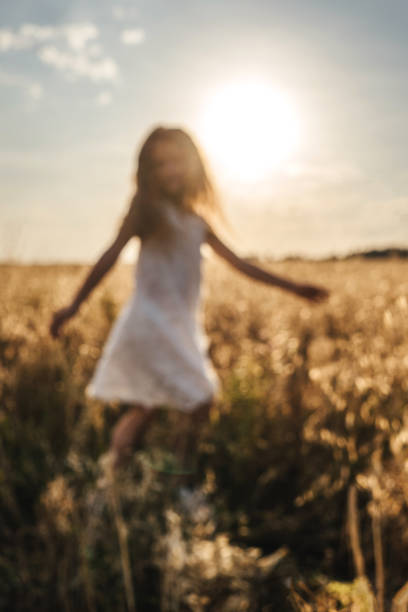 istock Little girl in field, sunset light. 1306452112