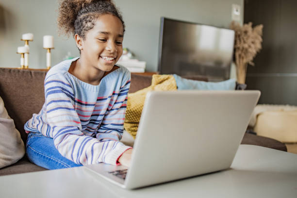 istock Little girl is using laptop at home 1306453627
