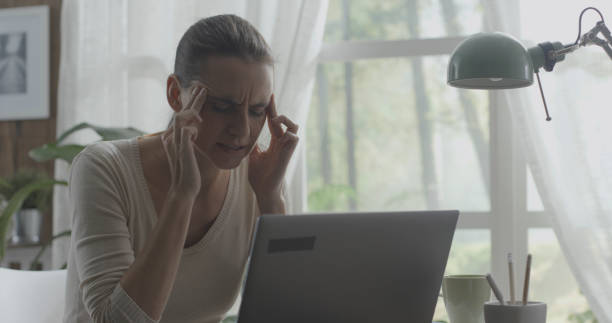 istock Exhausted woman with headache working in her office 1306453740