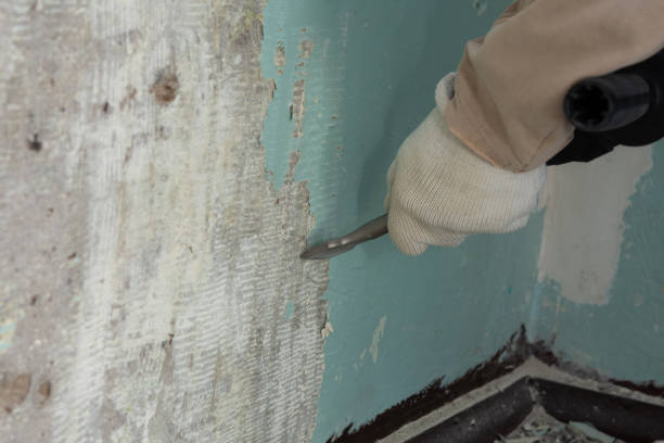 istock Worker removes old paint from a concrete wall 1306456222