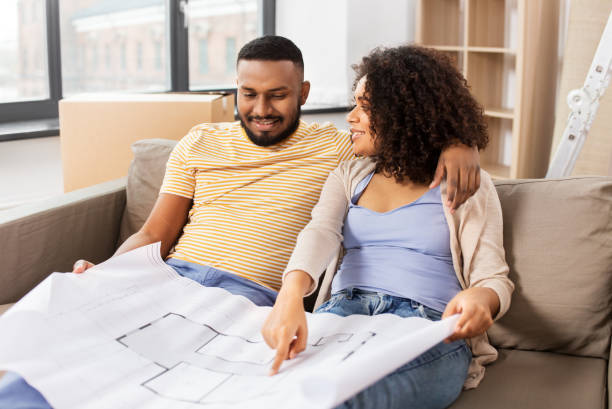 istock couple with boxes and blueprint moving to new home 1306456376