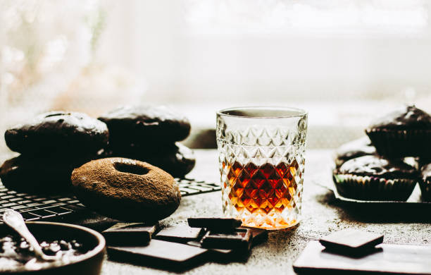 istock Whiskey on a background of chocolate donuts and the chocolate. 1306456529