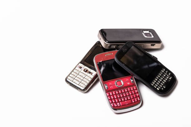 istock Recycle old mobile phones on white, electronic waste, Dust and scratched keyboard phone. copy space. 1306456534