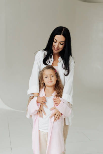 istock beautiful brunette mom with her daughter on a wall background 1306459872