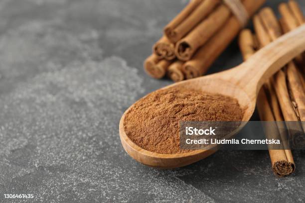 Aromatic Cinnamon Powder And Sticks On Grey Table Closeup Space For Text Stock Photo - Download Image Now