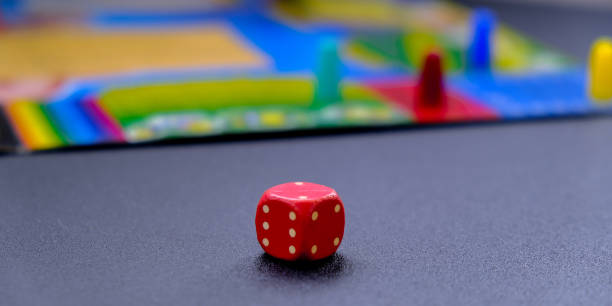 istock Dice for board games on black background. Board game with multi-colored cubes on table game. Monopoly. Stay home leisure activity 1306463559