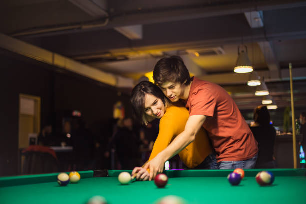 istock Boyfriend teaching his girlfriend to playing billiard. 1306464370