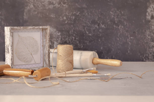istock Professional working tools for working with clay, plasticine and botanical bas-relie leaf. Pottery shovels, brushes, rolling pin on marble table. 1306464770
