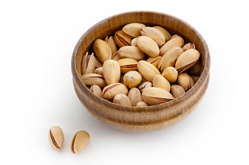 Fresh pistachios in a bamboo plate. Food background.