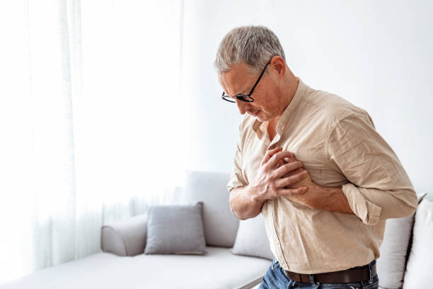 Chest pains are never a good sign Shot of a unrecognizable man holding his chest in discomfort due to pain at home during the day heartburn photos stock pictures, royalty-free photos & images