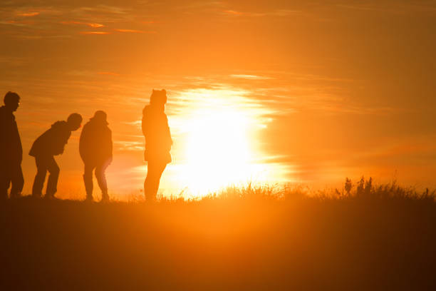 istock Travelers silhouettes against the orange light 1306473111