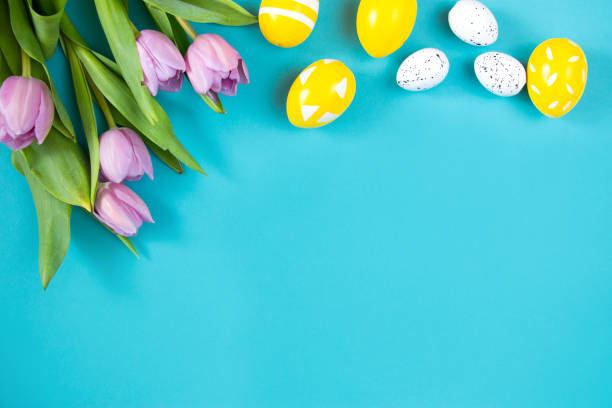 istock Tulips and painted Easter eggs on a blue background. Festive floral concept with clean text space. Flat lay. View from above. 1306474399