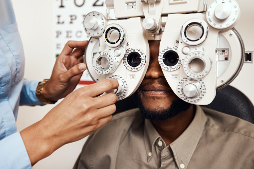 Shot of an optometrist examining her patient’s eyes with an optical refractor