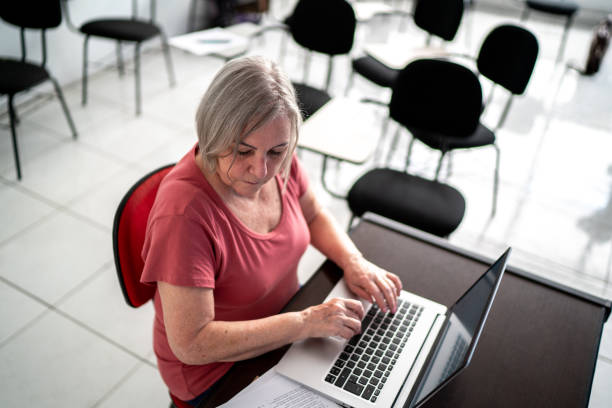 insegnante che usa laptop a scuola - grading teacher desk writing foto e immagini stock