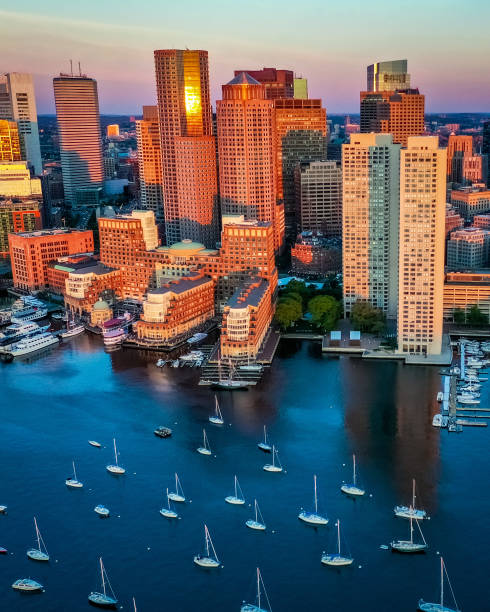 Summer Sun Rise in Boston, MA This is an aerial view of the summer sun, painting Boston’s skyline. The boats sit in the calm of the harbor while everyone’s day begins boston massachusetts stock pictures, royalty-free photos & images