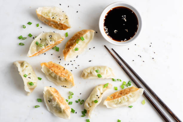 Gyoza fried chinese dumplings Gyoza fried chinese dumplings served with scallions, sesame seeds and soy sauce. Top view. Asian cuisine food chinese dumpling stock pictures, royalty-free photos & images