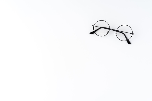 Overhead shot of round eyeglasses on white table with copyspace